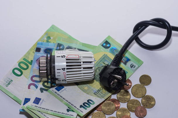 Enerji fiyatlarında artış ve enerji tüketimi termostatik denetim ısıtma ve elektrik prizi çok para ile - Fotoğraf, Görsel