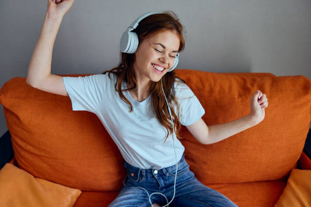 pretty woman headphone at home on the couch entertainment apartments - Foto, imagen