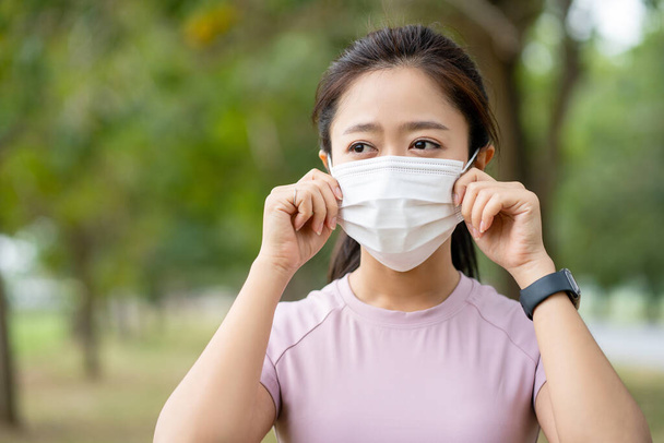 sport asia woman running in the park with a face mask in order to avoid infectious diseases coronavirus or air pollution - Φωτογραφία, εικόνα