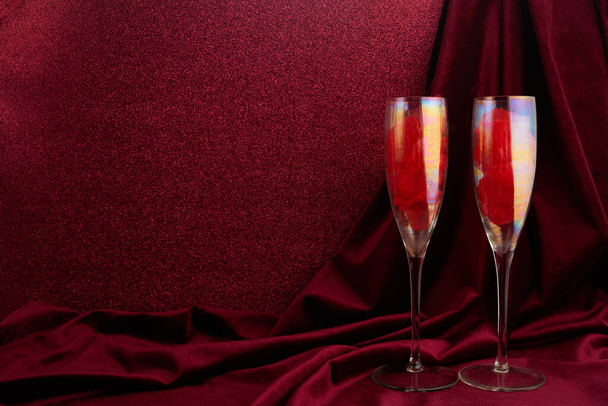 Valentines day background with champagne glasses and red ribbon on dark red background - Foto, Bild