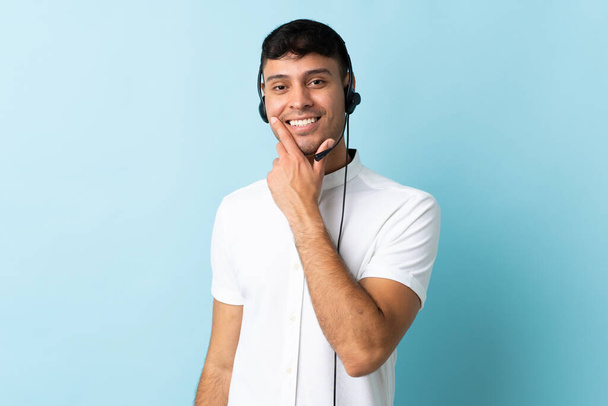 Telemarketer Kolumbijczyk pracuje z zestawu słuchawkowego na odizolowanym tle szczęśliwy i uśmiechnięty - Zdjęcie, obraz