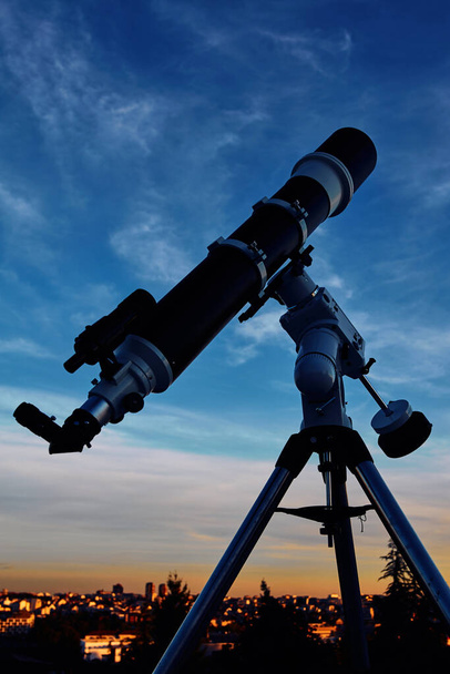 Большой астрономический телескоп под сумеречным небом, готовый к звездному глазу. - Фото, изображение