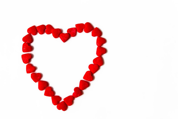 Rode harten vormen een hartvorm op een witte achtergrond. Geïsoleerde hartvorm. Het concept van liefde en romantiek. Romantische achtergrond compositie. Valentijnsdag. - Foto, afbeelding