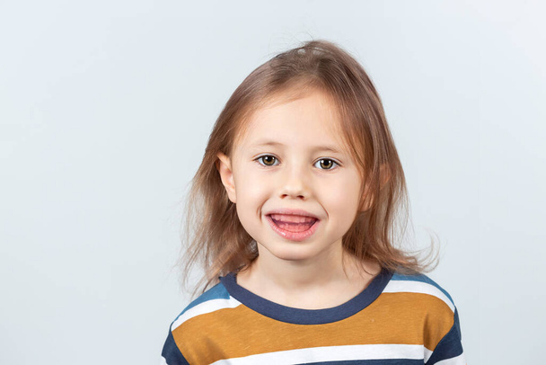Six-year old caucasian girl shows myofunctional trainer. dental tariner is made to help equalize the growing teeth and correct bite, develop mouth breathing habit and correct the position of tongue. - Zdjęcie, obraz
