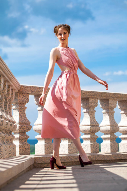 Full length portrait of young beautiful brunette woman in pink dress - Fotó, kép