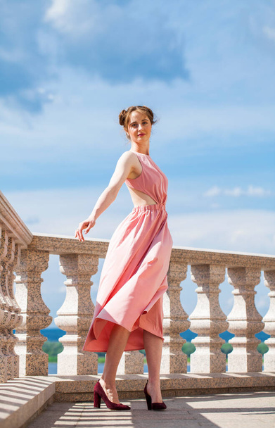 Full length portrait of young beautiful brunette woman in pink dress - 写真・画像