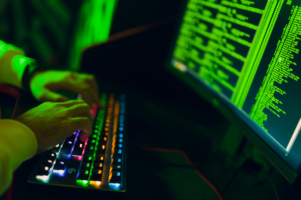 Hacker using computer malware software and hacking binary code digital interface. - Photo, image