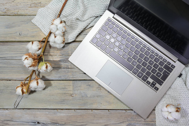 ordinateur portable avec quelques branches de coton et une écharpe sur une table en bois gris rustique, travail d'affaires en automne, espace de copie, vue grand angle d'en haut, mise au point sélectionnée - Photo, image