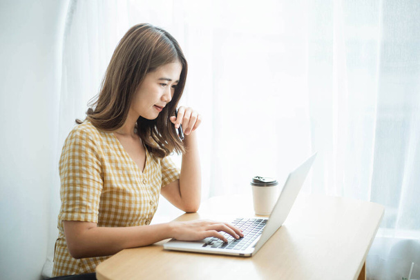 Conceito empreendedor uma jovem empresária digitando em um laptop para responder e-mails para seus clientes. - Foto, Imagem