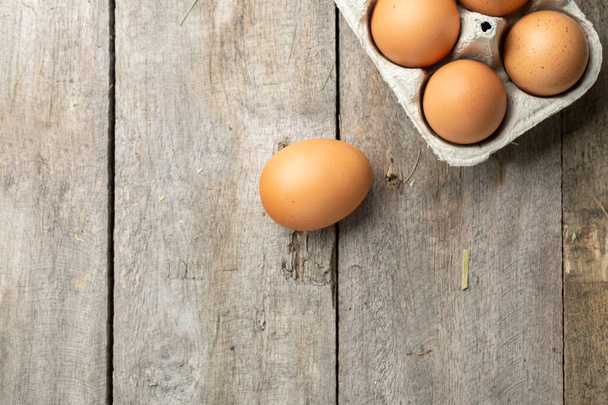 Fresh organic chicken eggs in carton or egg container on wood background. Farming and farming concept. Space for text. - Foto, Imagem