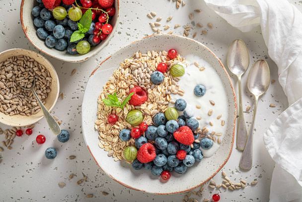 Tasty oats made of blueberries and raspberries. Breakfast with oat flakes and berries. - Foto, afbeelding