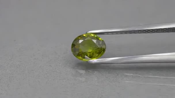 piedra de gema de granate demantoide verde natural en las pinzas - Imágenes, Vídeo