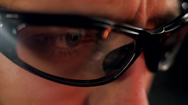 Ο άνθρωπος δουλεύει σε γυαλιά με ενσωματωμένο φακό και φωτισμό. Κοντινό πλάνο - Πλάνα, βίντεο