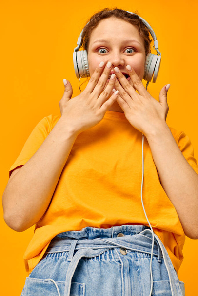 pretty girl yellow t-shirt headphones entertainment music fun isolated backgrounds unaltered - Foto, Bild