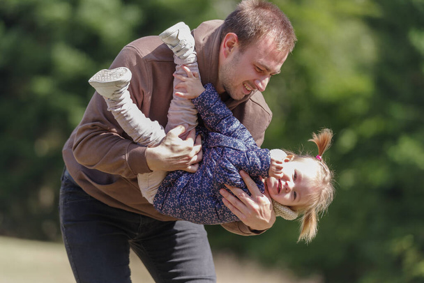 Isä nostaa iloinen lapsi tytär ulkona luonnossa - Valokuva, kuva