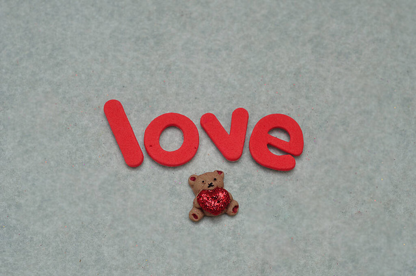 Slovo láska s malým medvídkem na bílém pozadí - Fotografie, Obrázek