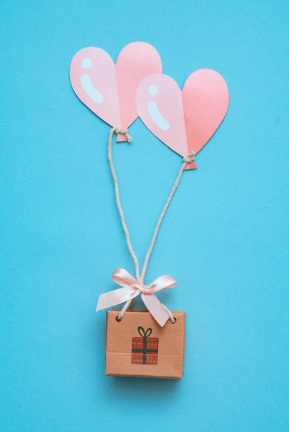 Флэтли с концепцией подарка на воздушные шары в виде сердечной мухи доставляет покупки на праздник с поздравлениями. - Фото, изображение