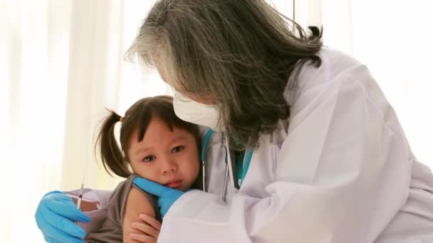 Ανώτερος γιατρός προσπαθεί να εμβολιάσει το παιδί και να προσπαθήσει να πείσει το παιδί να είναι απαλλαγμένο από το φόβο των ενέσεων που χρησιμοποιούνται για τη θεραπεία ασθενειών:. - Πλάνα, βίντεο