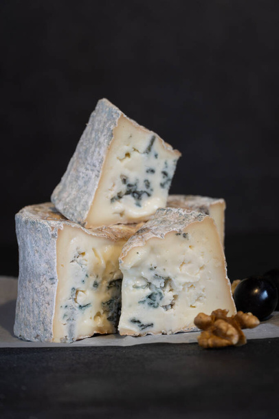 Gorgonzola sininen hometta juustoa viinirypäleitä ja pähkinöitä. Käsintehty. - Valokuva, kuva
