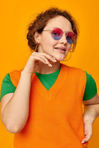 portrait of a young woman multicolored sunglasses on face posing grimace isolated backgrounds unaltered - Photo, image