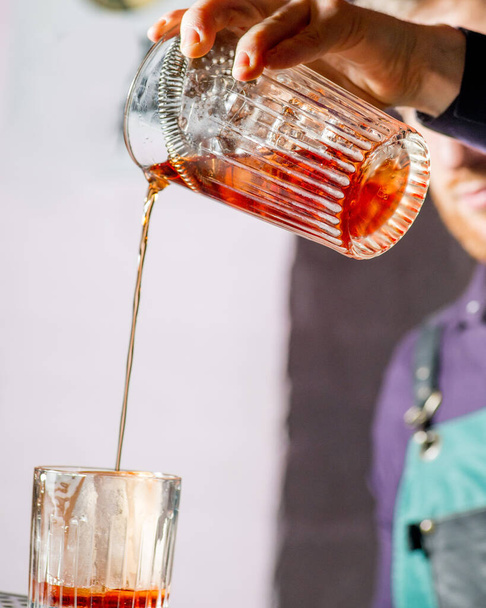 bartender pours a cocktail into a glass - Φωτογραφία, εικόνα