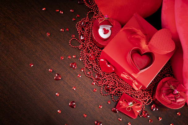 Valentines day concept. Red hearts,  boxes with valentines gifts and valentines decorations on the glass table. - Photo, Image