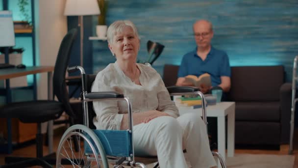 Portrét ženy v důchodu sedí na invalidním vozíku doma - Záběry, video