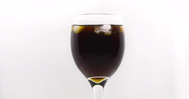 Buz küpü izole edilmiş bir kola bardağına düşer. Beyaz bir arka planda içki bardağı. - Video, Çekim