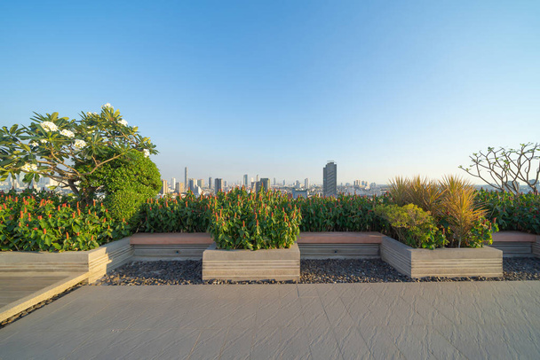 Sky garden on private rooftop of condominium or hotel, high rise architecture building with tree, grass field, and blue sky. - Foto, afbeelding