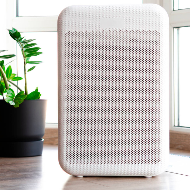 purificateur d'air dans une maison confortable pour le filtre et le nettoyage enlever la poussière PM2.5 HEPA et le virus dans la maison, pour l'air frais et la vie saine Wellness, concept de pollution de l'air - Photo, image