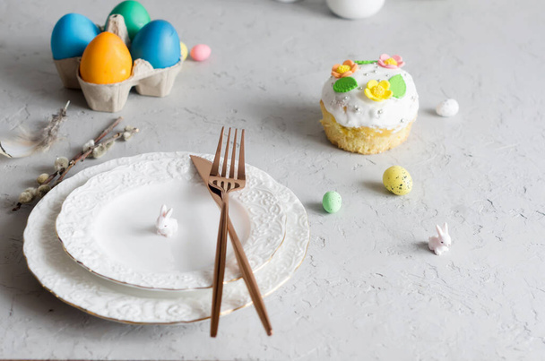 Place setting for Easter on the bright background with Easter cake with colorful topping, Decorative eggs sweets and holiday decorations - Fotó, kép