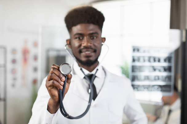 African doctor holding stethoscope and looking at camera - Foto, Imagem