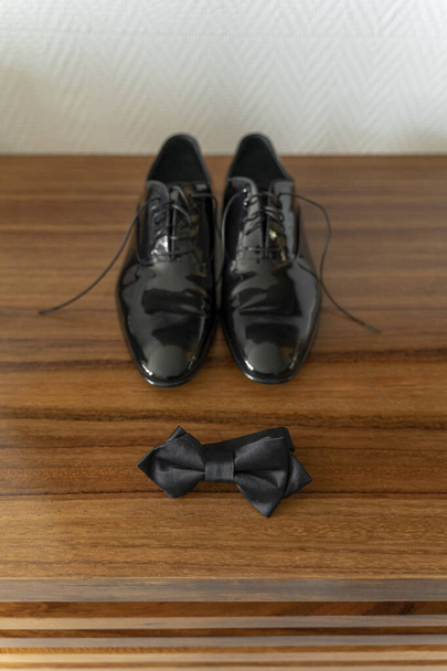 Chaussures de marié en cuir verni et noeud papillon sur meubles en bois se préparer concept - Photo, image