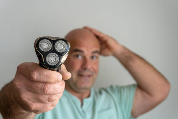  Rasoir électrique dans la main d'un homme caucasien avec une tête rasée - Photo, image