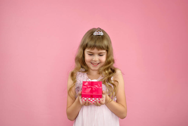 Menina alegremente posando em um fundo rosa. - Foto, Imagem