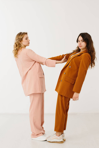 Jovens mulheres elegantes em roupas pastel em pé juntos, conceito de moda - foto stock - Foto, Imagem