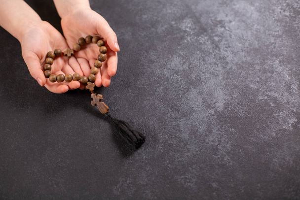 Childs hands holding the wooden cross and beads th in the shape of a heart. - Photo, image
