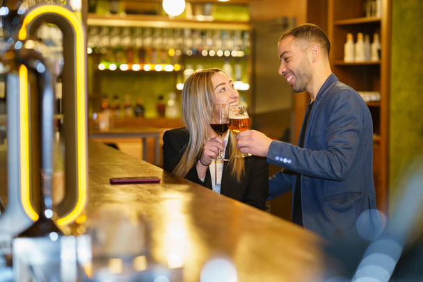 Couple multiethnique proposant des toasts dans un pub - Photo, image