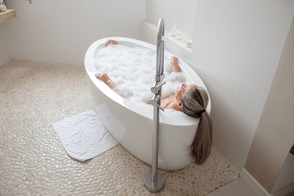 Nainen makaa kylpyammeessa ja lepää - Valokuva, kuva