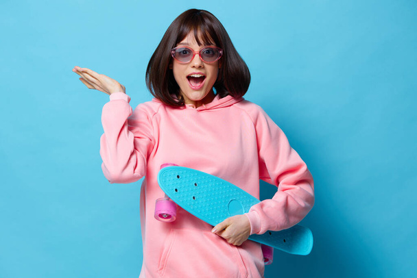 πορτρέτο γυναίκα έφηβος skateboard συναισθήματα νεολαίας μπλε φόντο - Φωτογραφία, εικόνα