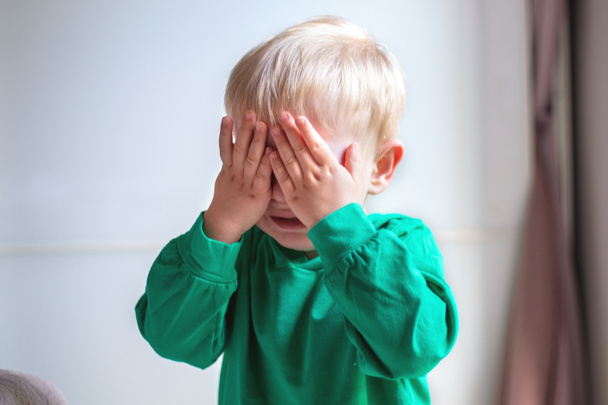 Porträt eines weinenden Kindes. Nahaufnahme. Kind bedeckt sein Gesicht mit den Händen - Foto, Bild