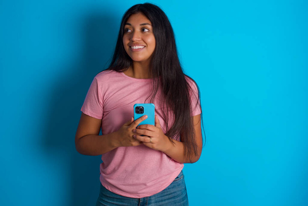 giovane bella ragazza latina che tiene in mano mostrando nuovo smartphone - Foto, immagini
