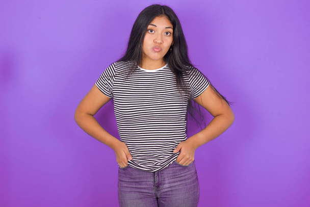 Portrait of lovely funny young latin woman wearing striped T-shirt   sending air kiss - Photo, Image