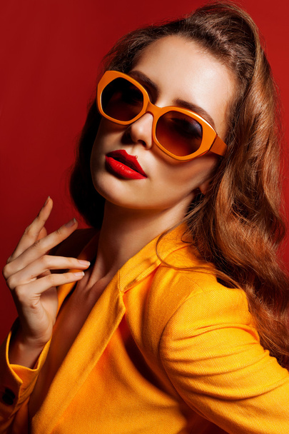 Модель в помаранчевій куртці та сонцезахисних окулярах
 - Фото, зображення