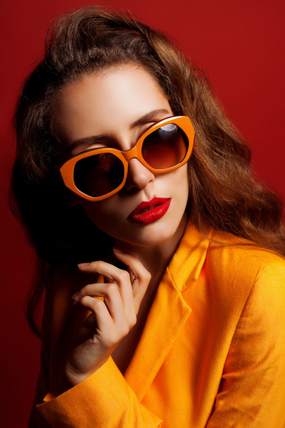 Модель в помаранчевій куртці та сонцезахисних окулярах
 - Фото, зображення