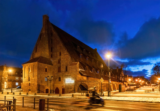 Gdansk, Polonia - 21 de enero de 2022: construcción de un gran molino de agua antiguo y el Museo del Ámbar en Gdansk, Polonia. Panorama nocturno del casco histórico de la ciudad medieval - Foto, Imagen