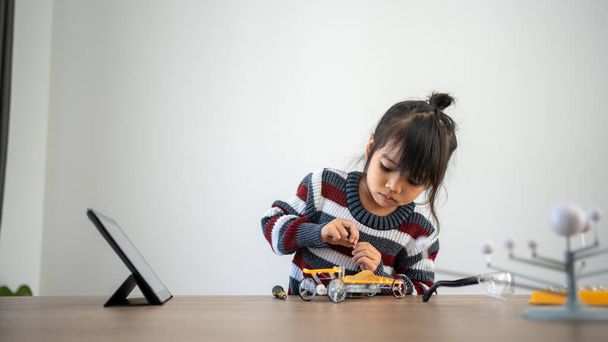 Asian girls enjoy making and fixing electrical robot car and learning online tutor training course - Foto, Imagem