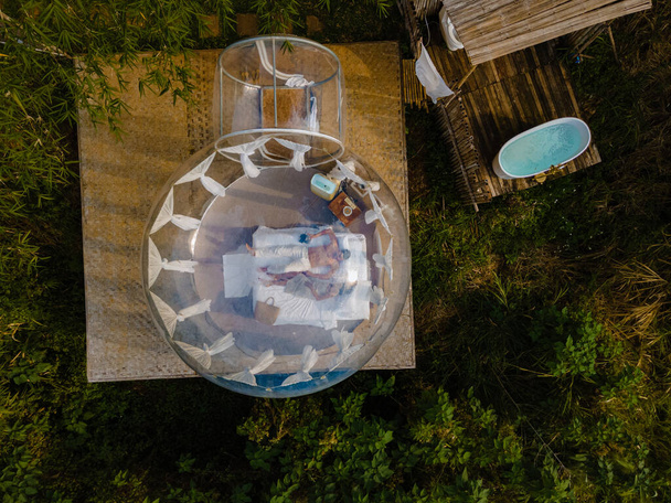 チェンマイの山の中でバブルドームテントの魅力、森の中で快適なベッドと枕で透明なベルテント、魅力的なホテル、豪華な旅行、豪華なキャンプ  - 写真・画像