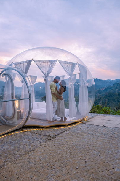 Bubble koepel tent glamping in de bergen van Chiang Mai Thailand, Transparante bel tent met comfortabel bed en kussen in het bos, glamping hotel, luxe reizen, glamoureuze camping  - Foto, afbeelding