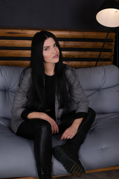 jonge aantrekkelijke vrouw in zwart in grijze loft kamer. trendy kleding. mode vrouwelijk portret - Foto, afbeelding